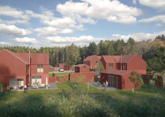 Ett av parhusen i BRF Kårsta Park 3 med falurött träpanel, uteplats och omgivande grönska